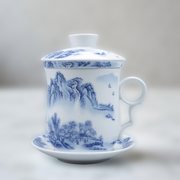 White ceramic teacup with blue landscape design on a white background