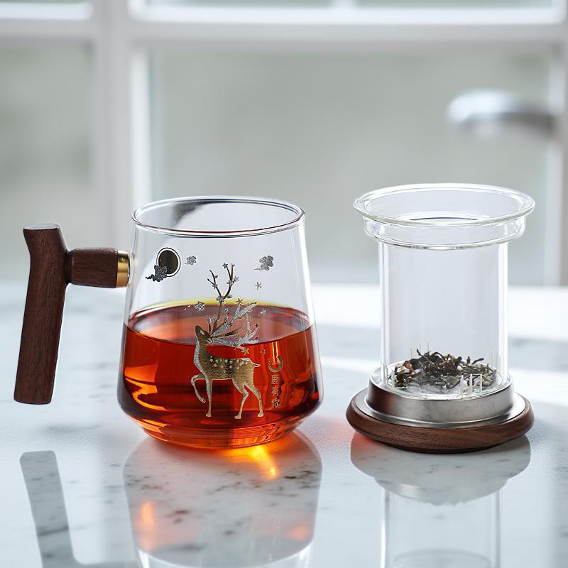 Glass teapot with wooden handle and glass container with wooden base on a marble surface