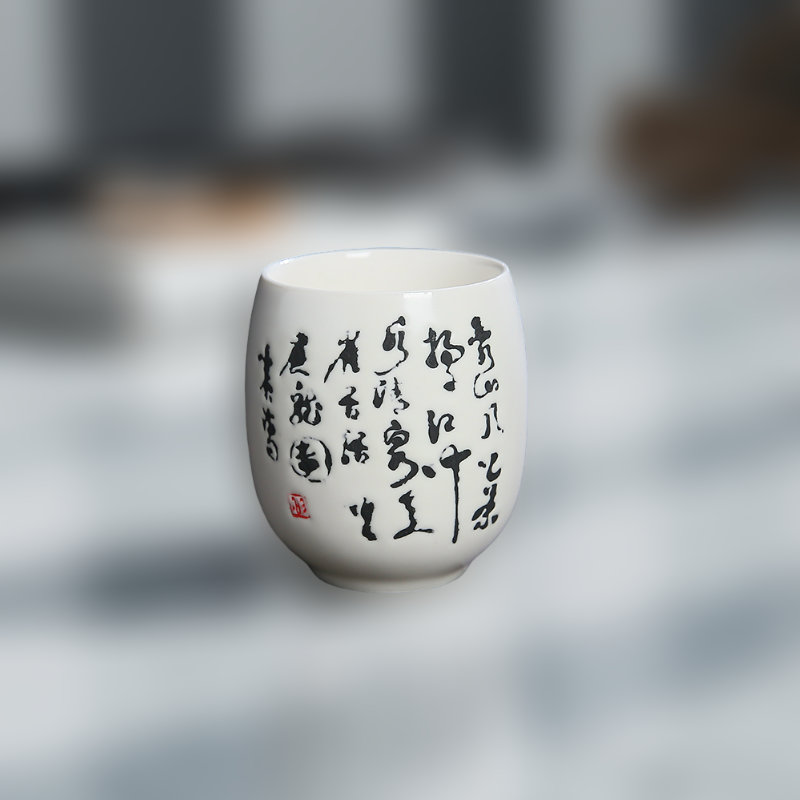 White ceramic cup with black calligraphy on a blurred background