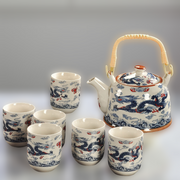 Ceramic teapot and cups with dragon design on a gray background
