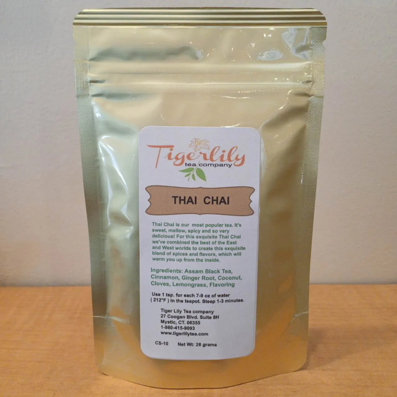 Tiger Lily Tea Company Thai Chai tea package on a wooden surface with a white background