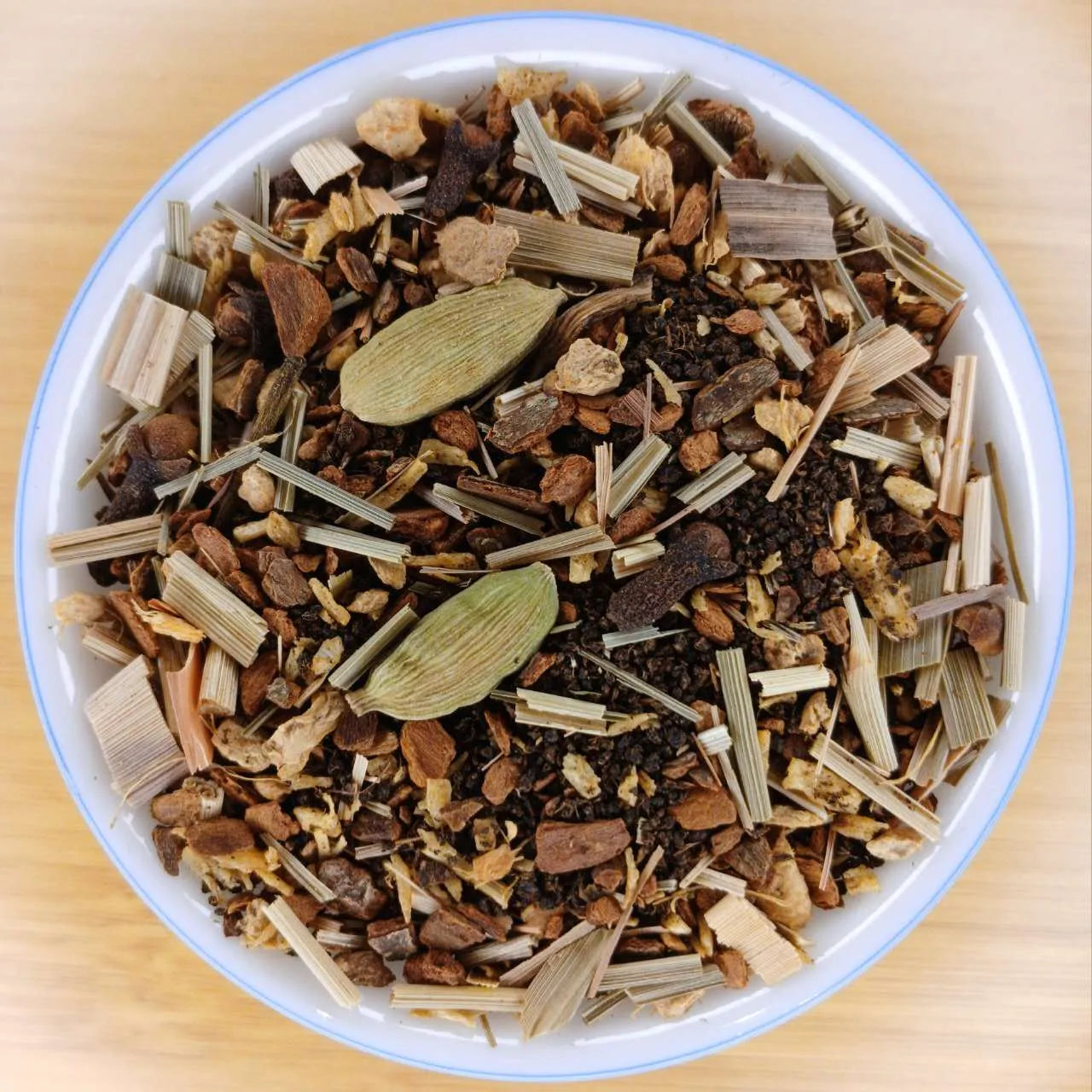 Herbal tea mix in a white bowl on a wooden surface
