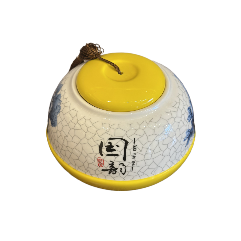 Ceramic container with yellow lid and cracked white design on a white background