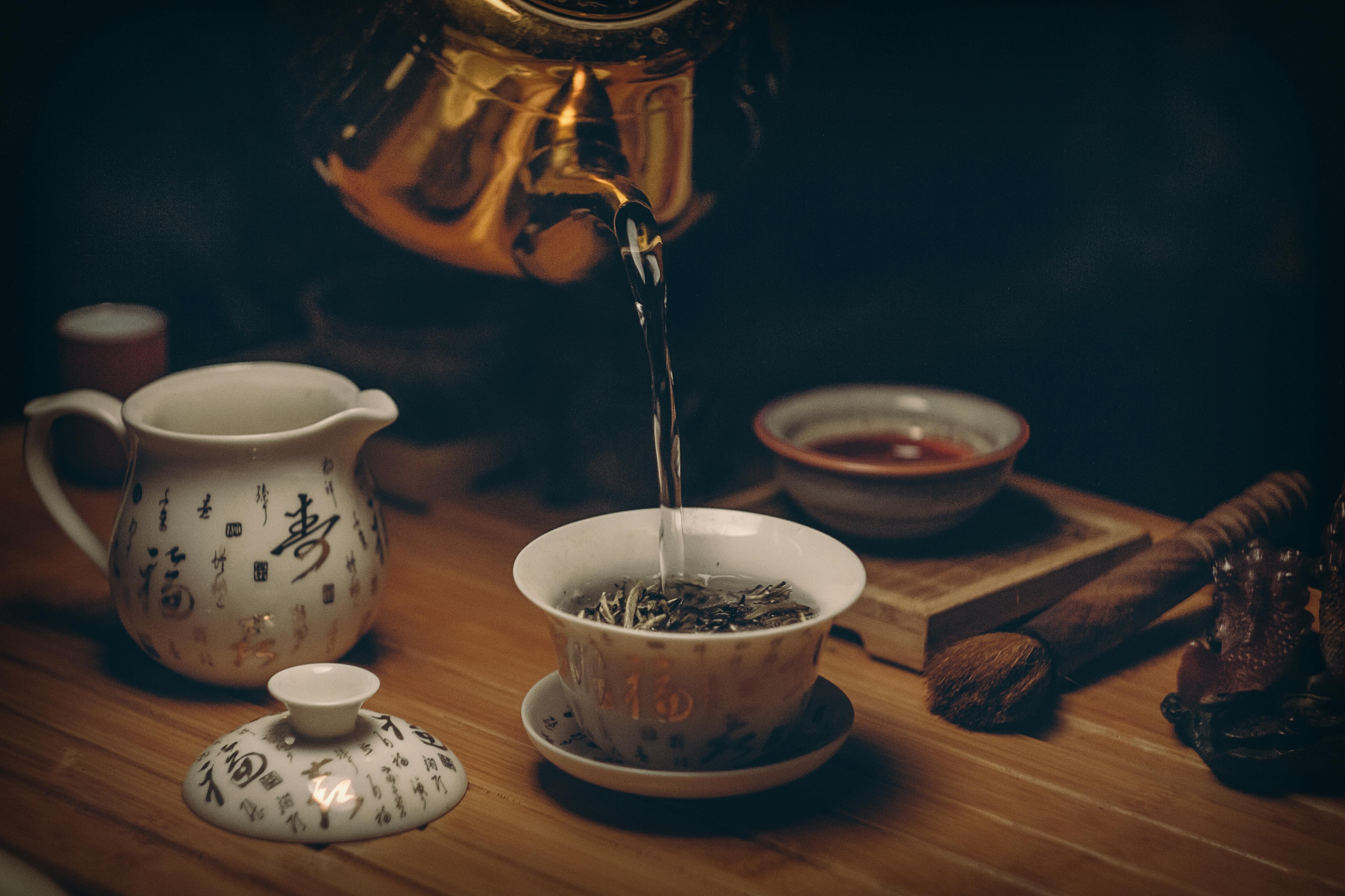 Hot organic loose leaf tea being poured into a porcelain cup – Tigerlily Tea CT