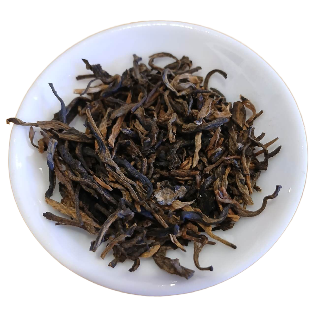 Dry black tea leaves in a white bowl on a white background